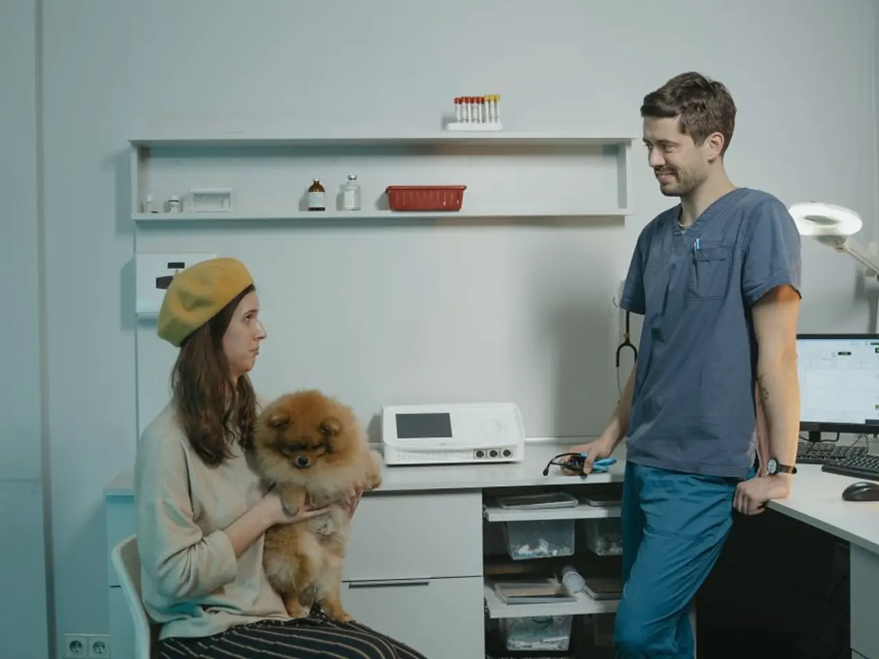 Tutora com seu cachorro no colo sendo atendida pelo veterinário na clínica